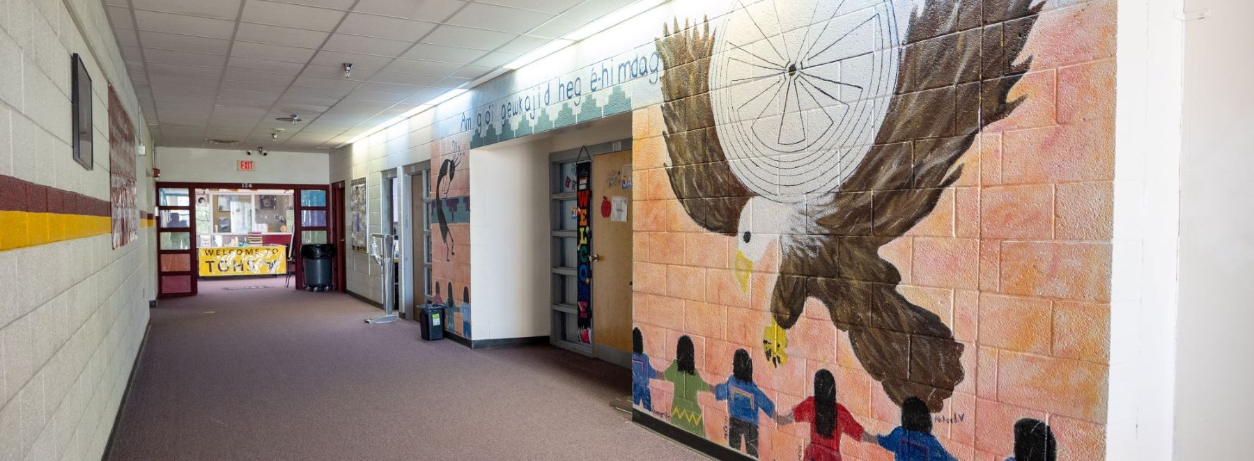 School hallway featuring a vibrant mural of an eagle on the wall.